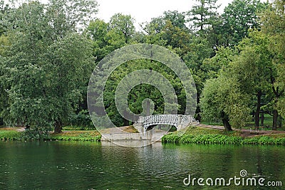 Landscape with old bridge over flow in the palace park