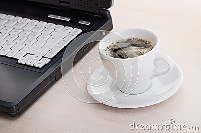 Laptop with fresh cup of coffee and notebook