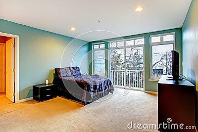 Large blue bedroom with purple bed and balcony door.