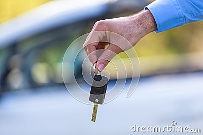 Latin american driver holding car keys driving his new car