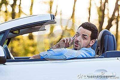 Latin american driver making a phone call while driving