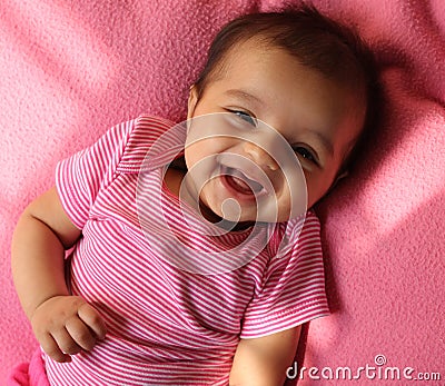 Laughing asian baby girl in pink cloths