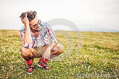 Laughing crouched man passing his hand through his hair