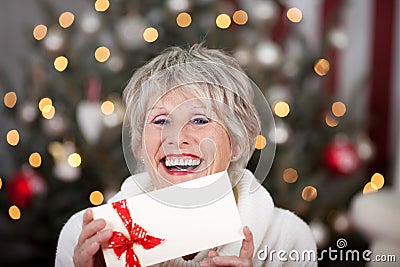 Laughing elderly lady with an Xmas gift voucher