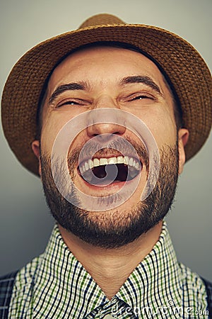 Laughing hipster man over grey