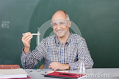 Laughing science teacher holding up a test tube