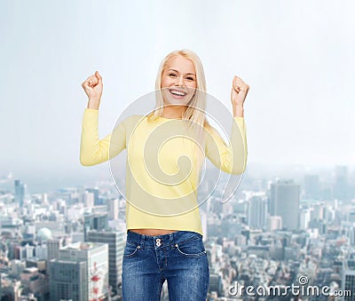 Laughing young woman with hands up