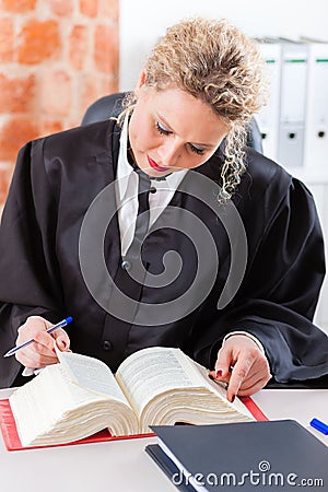 Lawyer in office reading law book