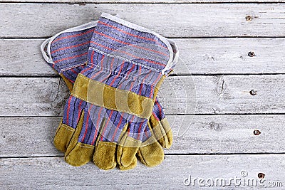 Leather work gloves lying on wooden board