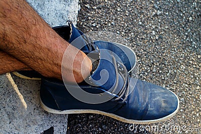 Legs crossed with blue shoes