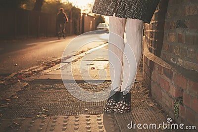 Legs of a woman resting against wall