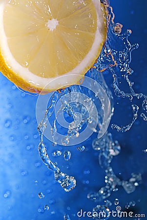 Lemon splashing in blue water