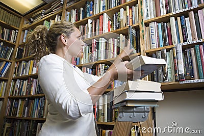 Librarian Arranging Books At Library