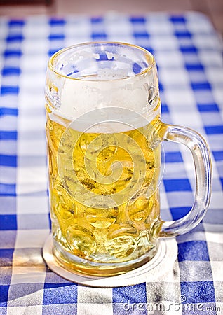 Light Beer in a glass pint mug served on a wooden