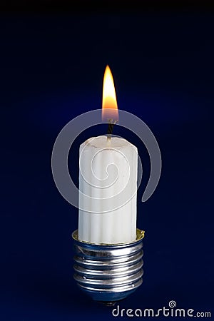 Light bulb fitting with no glass and candle standing on bright b