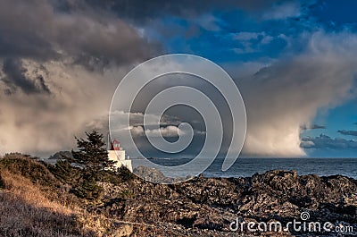 Lighthouse Along Rocky Shore With Storm Clouds in Distance