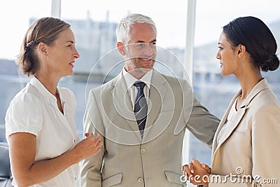 Likeable businessman speaking with female colleagues