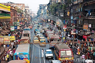 Lines of the yellow Ambassador taxi cabs and buses on the road of the city