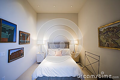 Lit Lamps By Bed With Frames On Wall In Bedroom