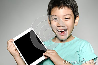 Little asian boy smiles with tablet computer