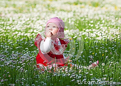Little baby on green grass and flowers