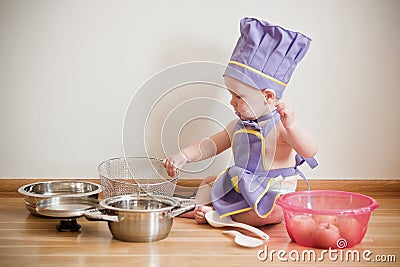 Little boy in a chief hat and aprons cooking
