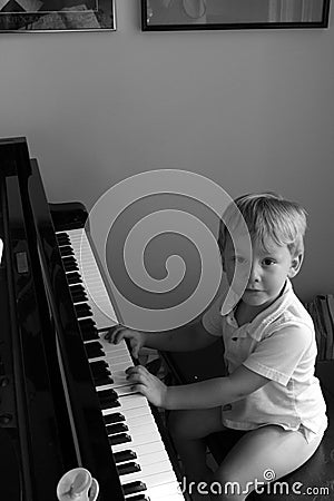 Little boy at concert grand piano