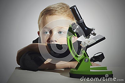 Little boy don t wont to study.sad child.Schoolboy working with a microscope.Smart boy.Education