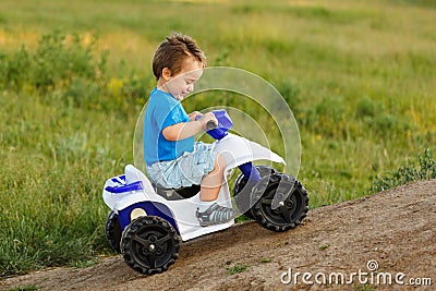 Little boy driving off road toy quad