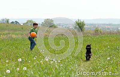 Little boy with football and his dog outdoors