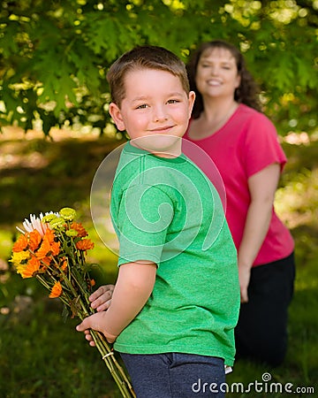 Little boy giving flowers to his mom