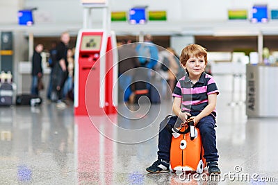 Little boy going on vacations trip with suitcase at airport