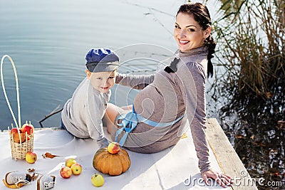 Little boy with her mother on the autumn lake