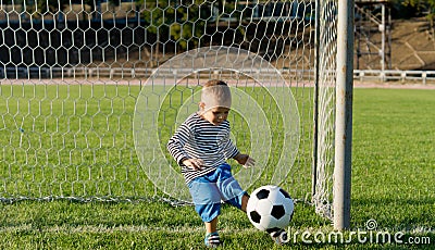 Little boy kicking a ball