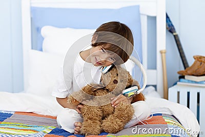 Little boy playing with headphones and teddy bear