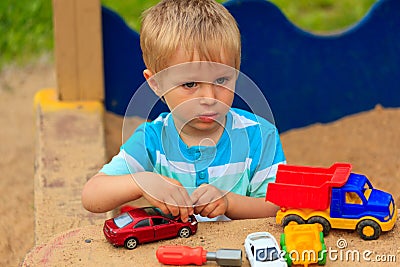 Little boy playing with toy trucks