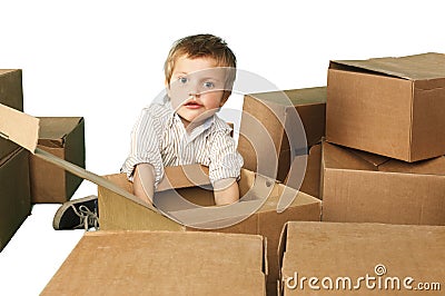 Little boy plays in boxes