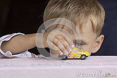 Little boy plays a toy car