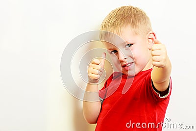 Little boy showing thumb up success hand sign gesture.