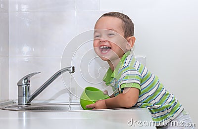 Little boy washing dishes