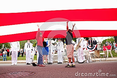 Little boys reach underneath US Flag