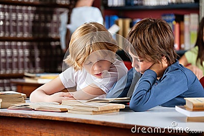 Little Boys Reading Book Together In Library