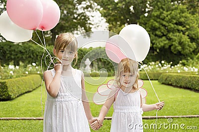 Little Bridesmaids Holding Balloons In Garden