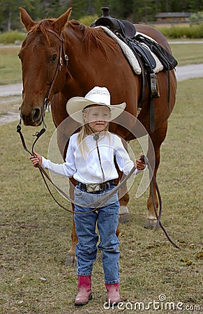 Little Cowgirl Holding Chestnut/Sorrel Horse