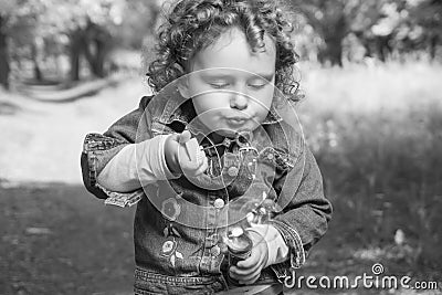 Little curly girl with soap bubbles