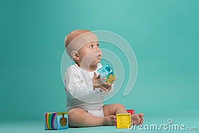 Little cute baby boy playing with color blocks