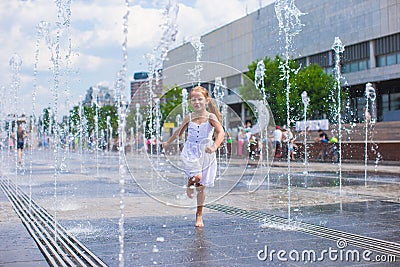 Little cute girl walking in open street fountain