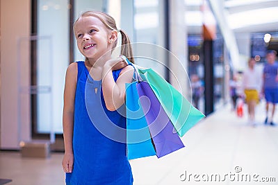 Little fashion girl with packages in a large