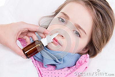 Little girl with bad cold using nasal drops.