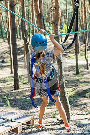 Little girl climbs on rope harness